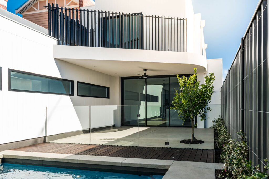 Exterior of a modern home with a pool and concrete patio