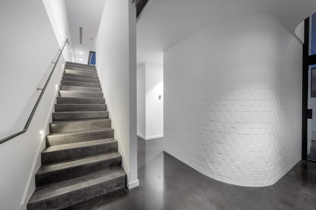 Hallway with polished black concrete floor and stairs
